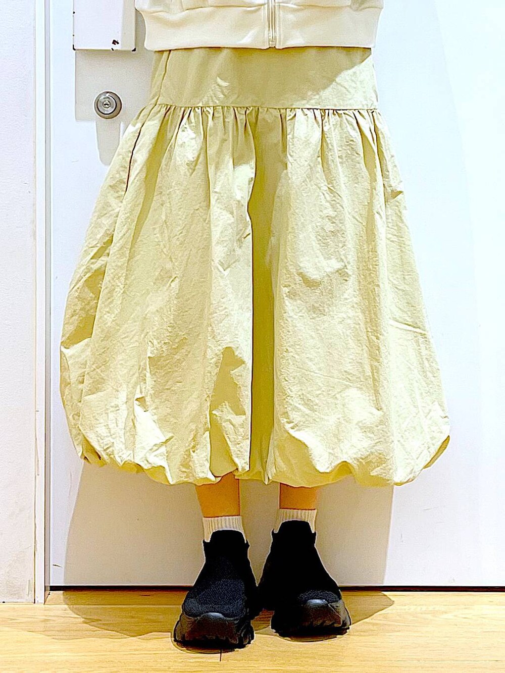 ベージュ系のブルゾン、ベージュ系のスカート、ホワイト系のショルダーバッグを着用したレディースの冬コーディネートの8枚目の写真