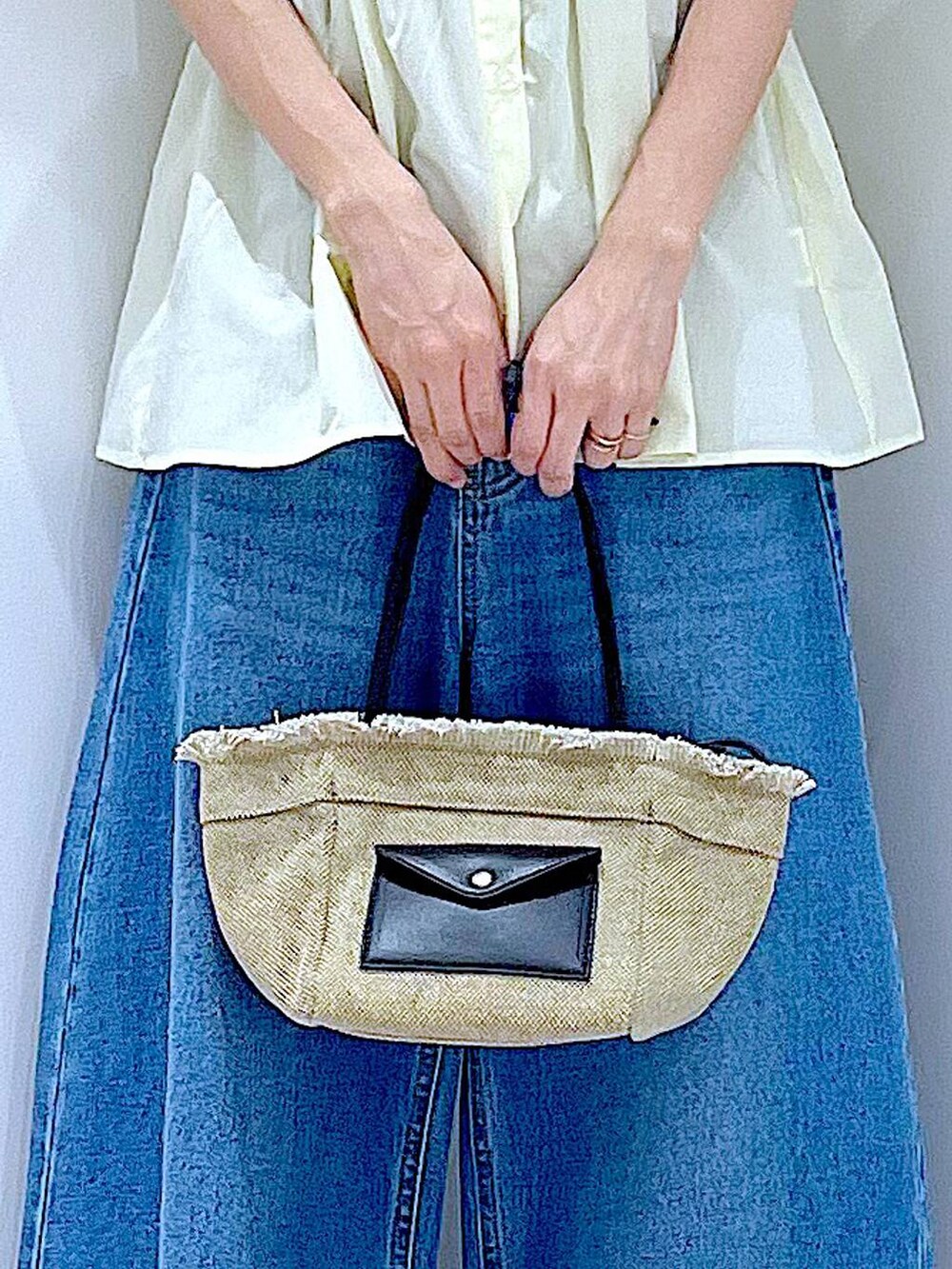 ブルー系のデニムパンツ、ベージュ系のショルダーバッグ、シルバー系のサンダルを着用したレディースの夏コーディネートの9枚目の写真