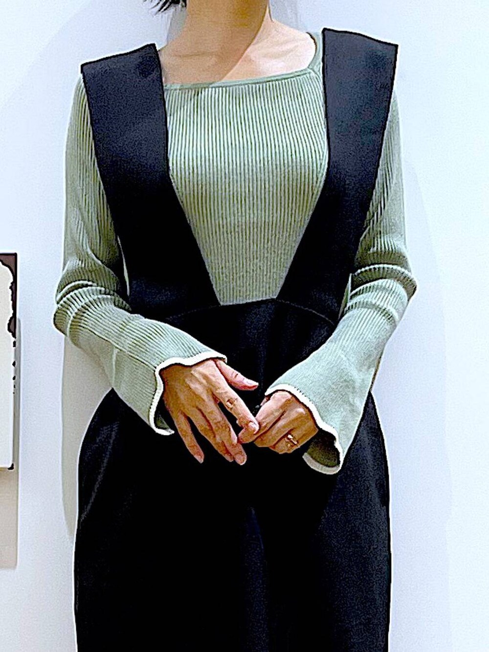 グリーン系のニット/セーター、ブラック系のブーツ、ブラック系のサロペット/オーバーオールを着用したレディースの冬コーディネートの7枚目の写真