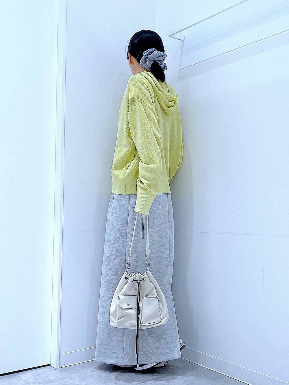 ベージュ系のショルダーバッグ、グレー系のスカート、イエロー系のカーディガン/ボレロを着用したレディースの春コーディネートの3枚目の写真