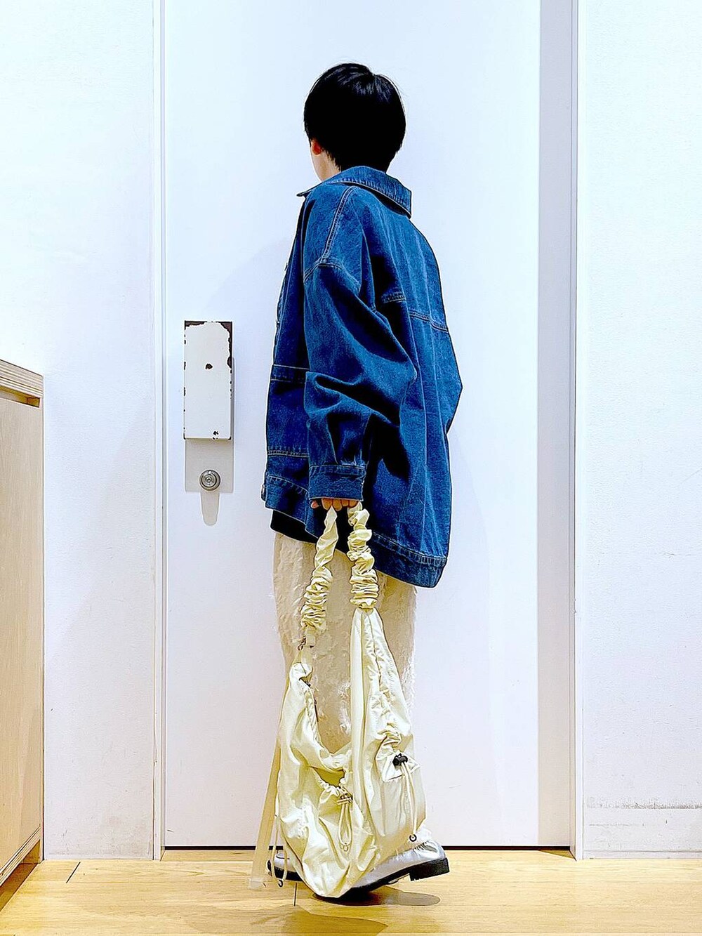 シルバー系のローファー、ブルー系のスウェット、ブルー系のデニムジャケットを着用したレディースの春コーディネートの3枚目の写真