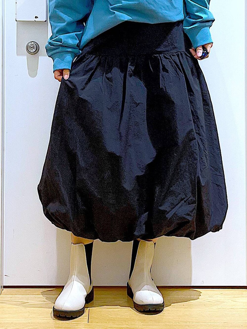 グリーン系のTシャツ/カットソー、ベージュ系のブーツ、ホワイト系のショルダーバッグを着用したレディースの春コーディネートの8枚目の写真