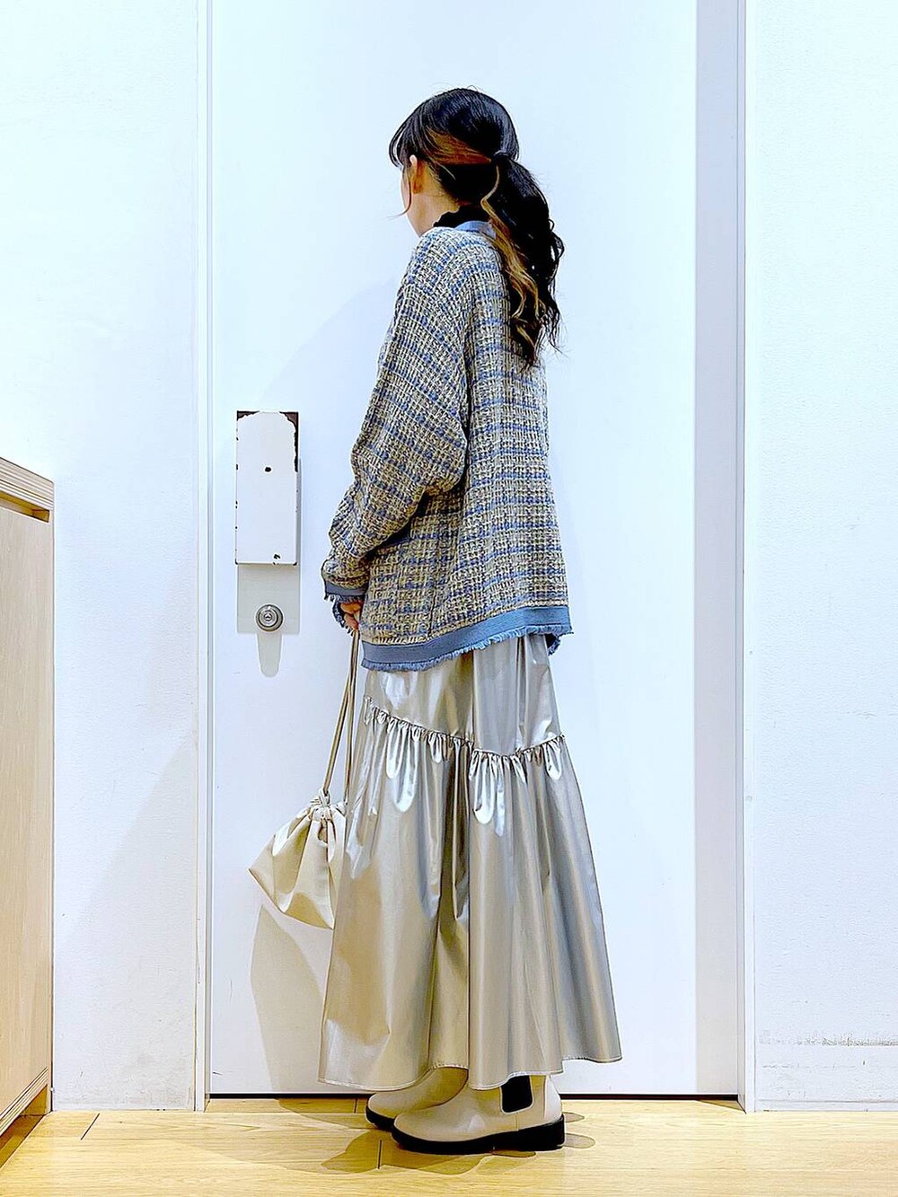 ブラック系のTシャツ/カットソー、シルバー系のスカート、ブルー系のカーディガン/ボレロを着用したレディースの冬コーディネートの3枚目の写真