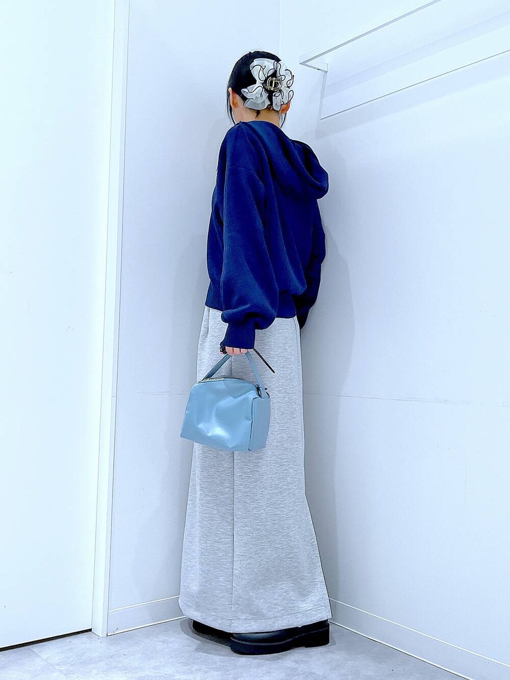 ブルー系のショルダーバッグ、ブラック系のサンダル、グレー系のスカートを着用したレディースの春コーディネートの3枚目の写真