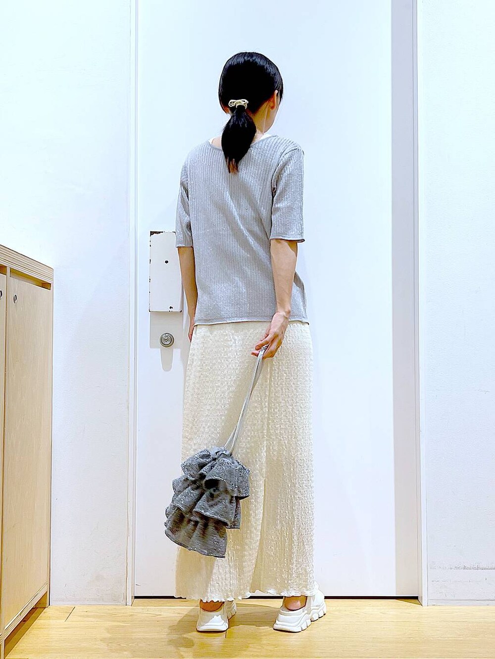 シルバー系のショルダーバッグ、ホワイト系のニット/セーター、ホワイト系のサンダルを着用したレディースの夏コーディネートの5枚目の写真