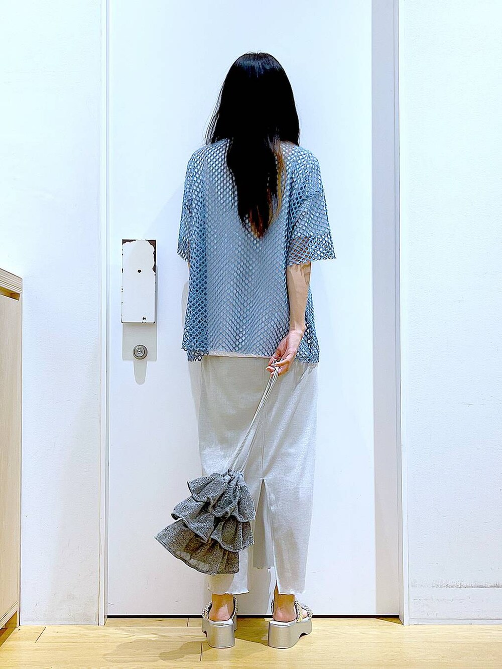 グレー系のスカート、シルバー系のショルダーバッグ、ホワイト系のTシャツ/カットソーを着用したレディースの夏コーディネートの5枚目の写真