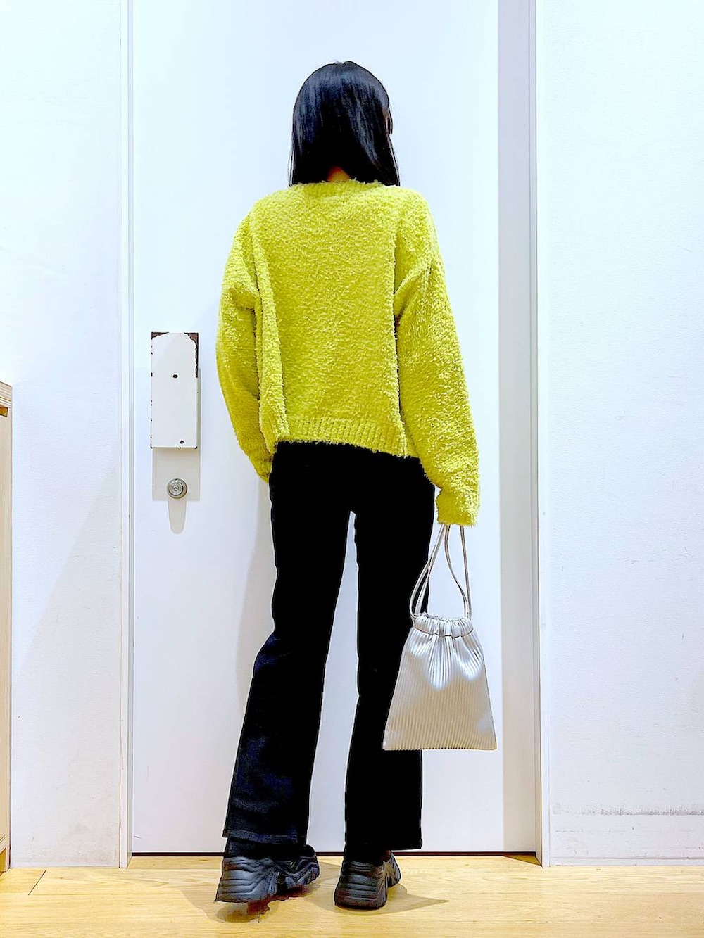 グリーン系のニット/セーター、グレー系のデニムパンツ、シルバー系のショルダーバッグを着用したレディースの冬コーディネートの5枚目の写真