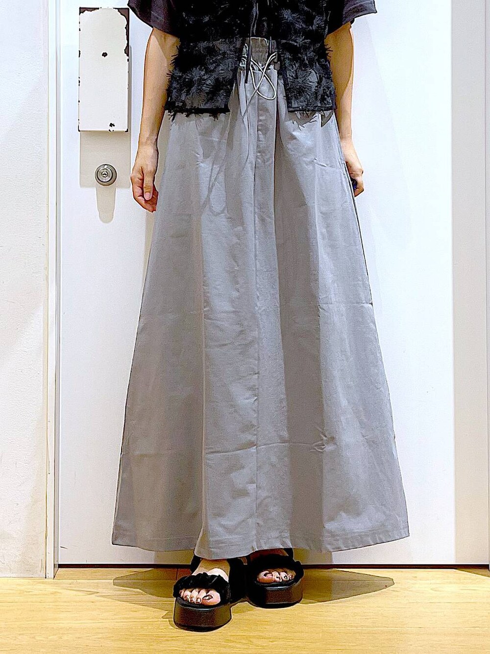 ブラック系のサンダル、ブラック系のショルダーバッグ、グレー系のスカートを着用したレディースの秋コーディネートの8枚目の写真