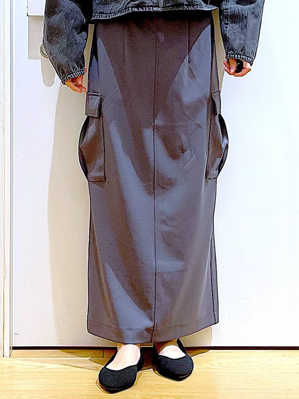 グレー系のデニムジャケット、ブラック系のトートバッグ、グレー系のスカートを着用したレディースの春コーディネートの8枚目の写真