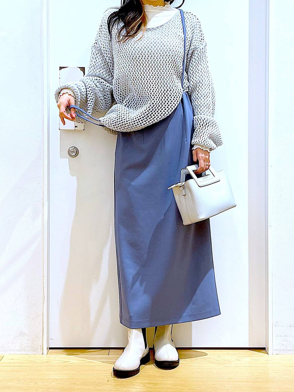 ホワイト系のTシャツ/カットソー、グレー系のニット/セーター、ベージュ系のブーツを着用したレディースの冬コーディネートの6枚目の写真