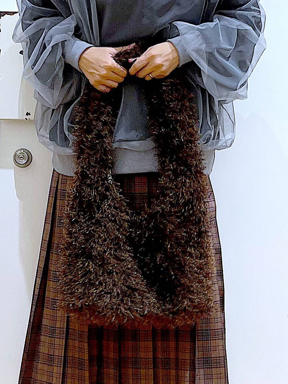 ブラック系のブーツ、ブラウン系のショルダーバッグ、ブラウン系のスカートを着用したレディースの秋コーディネートの9枚目の写真