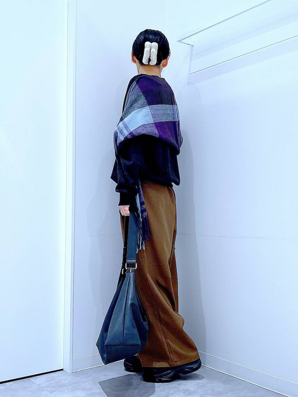 ブラック系のブーツ、ブラウン系のその他パンツ、ブラック系のショルダーバッグを着用したレディースの冬コーディネートの3枚目の写真