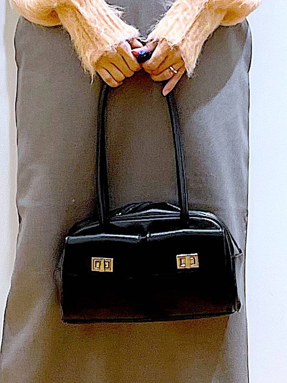 ピンク系のニット/セーター、ブラック系のハンドバッグ、ブラック系のブーツを着用したレディースの冬コーディネートの9枚目の写真