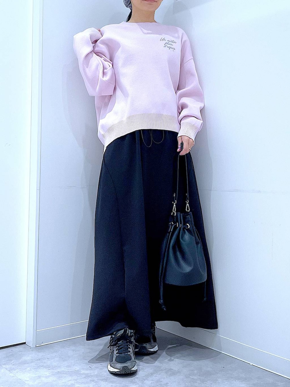 ピンク系のニット/セーター、ブラック系のショルダーバッグ、ブラック系のスカートを着用したレディースの春コーディネートの6枚目の写真