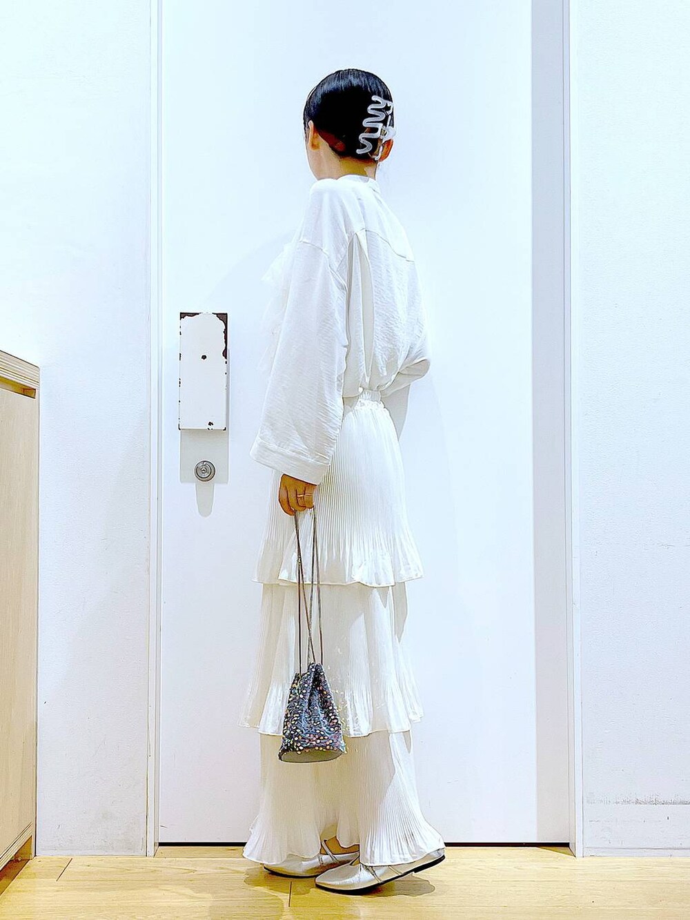 ベージュ系のスカート、シルバー系のパンプス、ホワイト系のシャツ/ブラウスを着用したレディースの秋コーディネートの3枚目の写真