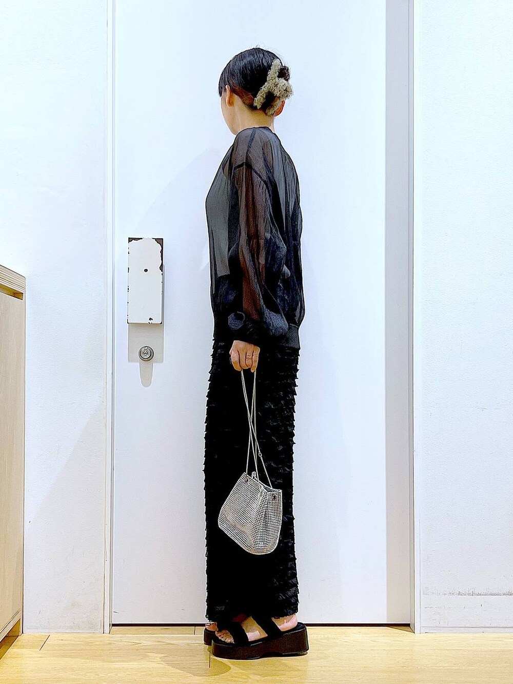 ブラック系のサンダル、ブラック系のブルゾン、ホワイト系のニット/セーターを着用したレディースの夏コーディネートの3枚目の写真