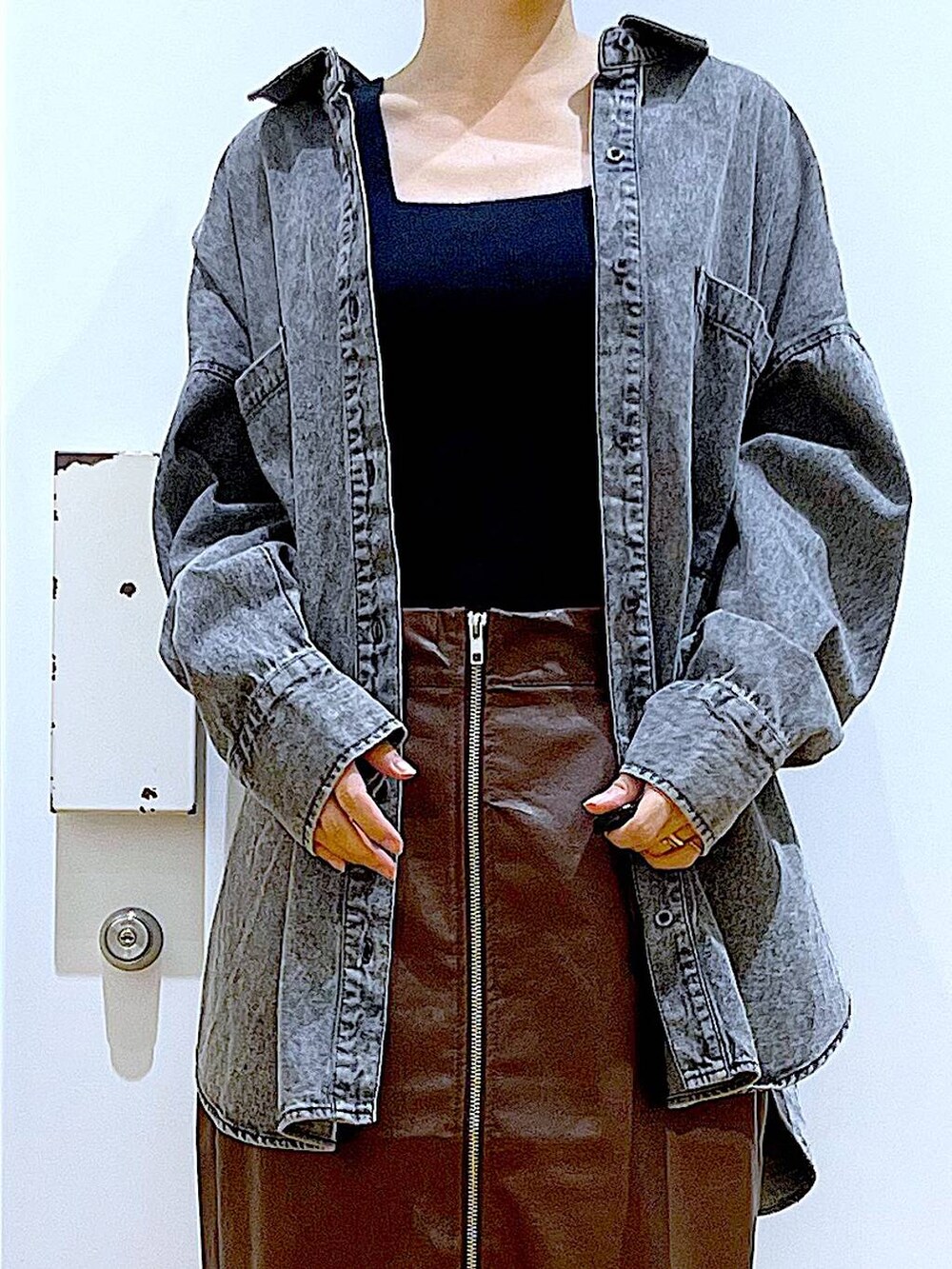 ブラウン系のスカート、ブラック系のニット/セーター、ブラック系のショルダーバッグを着用したレディースの秋コーディネートの7枚目の写真