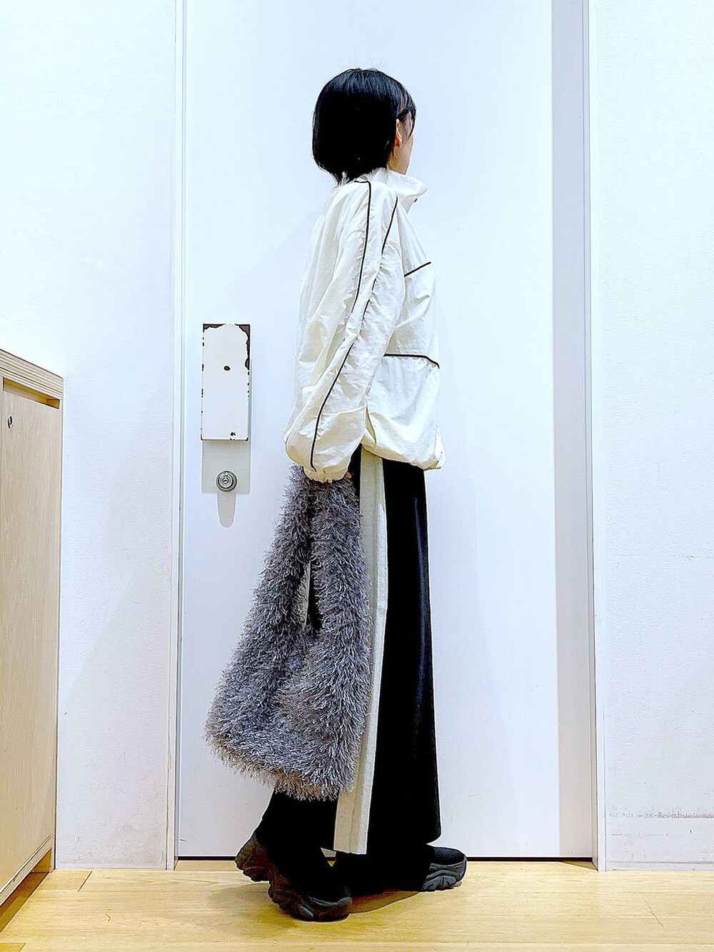 ブラック系のスカート、ベージュ系のブルゾン、グレー系のショルダーバッグを着用したレディースの秋コーディネートの4枚目の写真