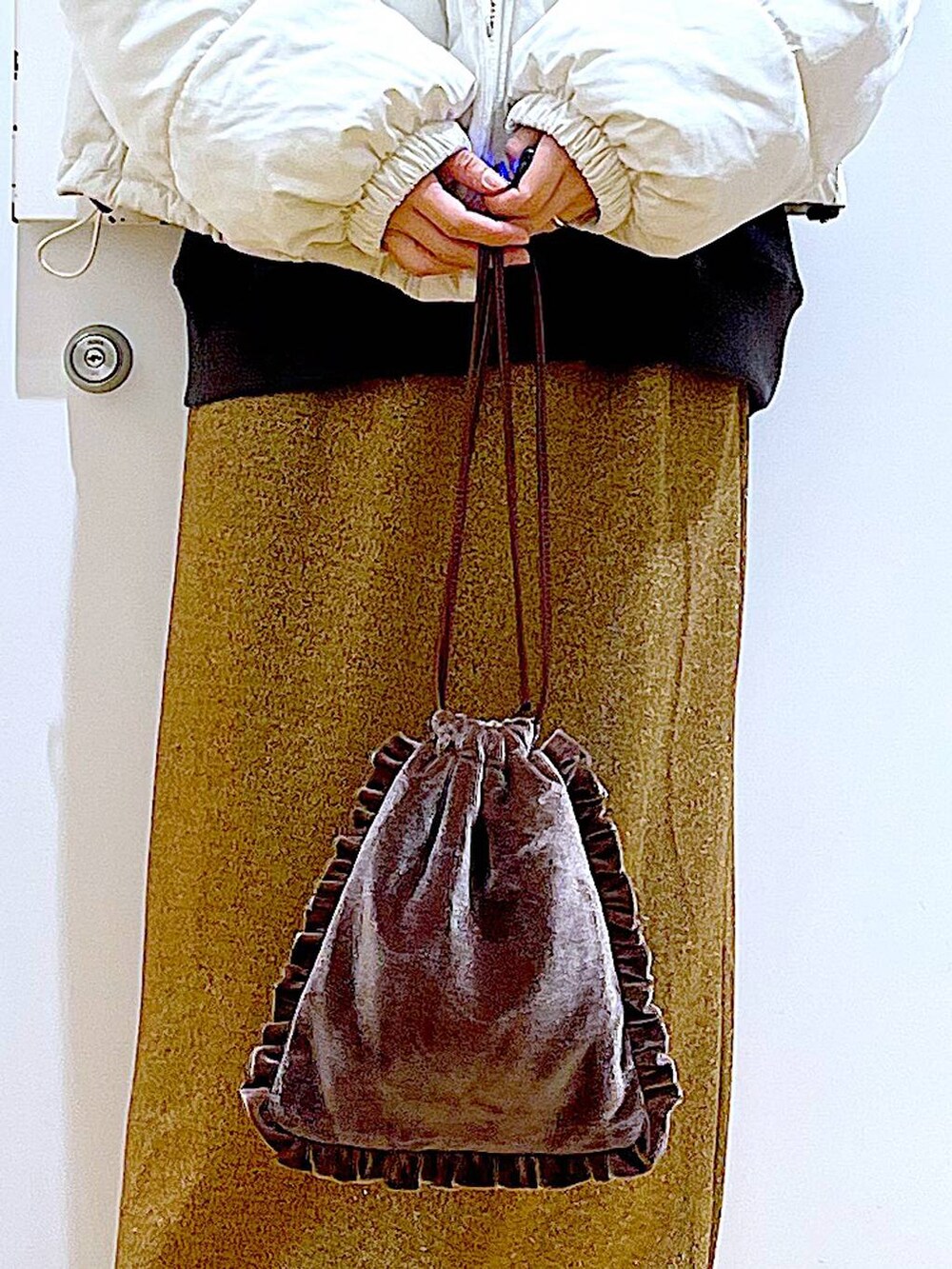 ベージュ系のブルゾン、ブラウン系のショルダーバッグ、ブラック系のブーツを着用したレディースの冬コーディネートの9枚目の写真