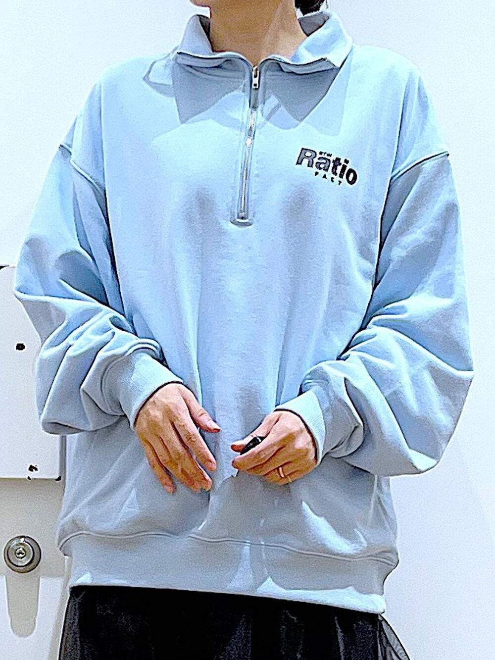 ブルー系のスウェット、ブラック系のブーツ、ホワイト系のショルダーバッグを着用したレディースの春コーディネートの7枚目の写真