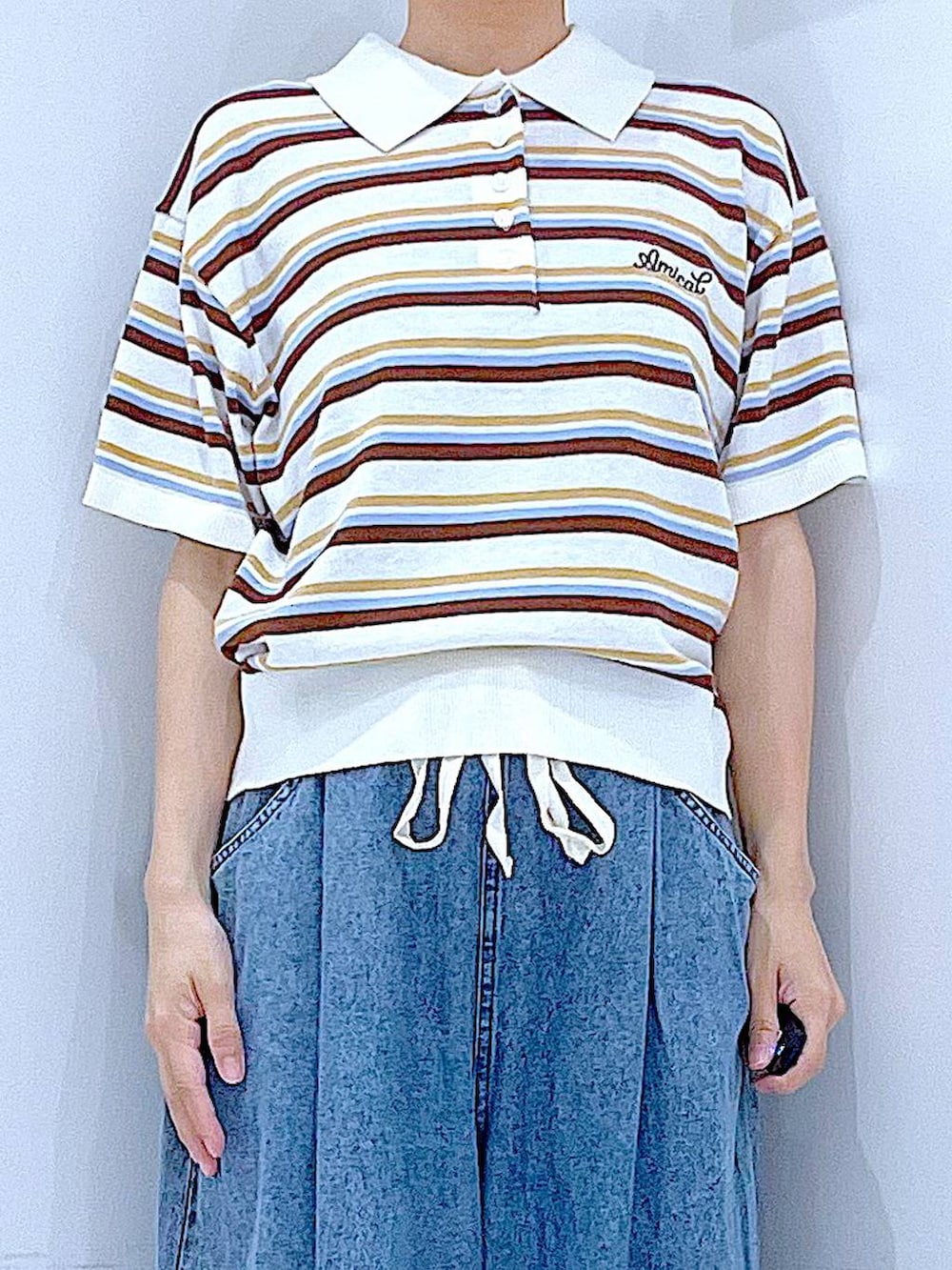 ブラック系のサンダル、ブルー系のデニムパンツ、ホワイト系のトートバッグを着用したレディースの夏コーディネートの7枚目の写真