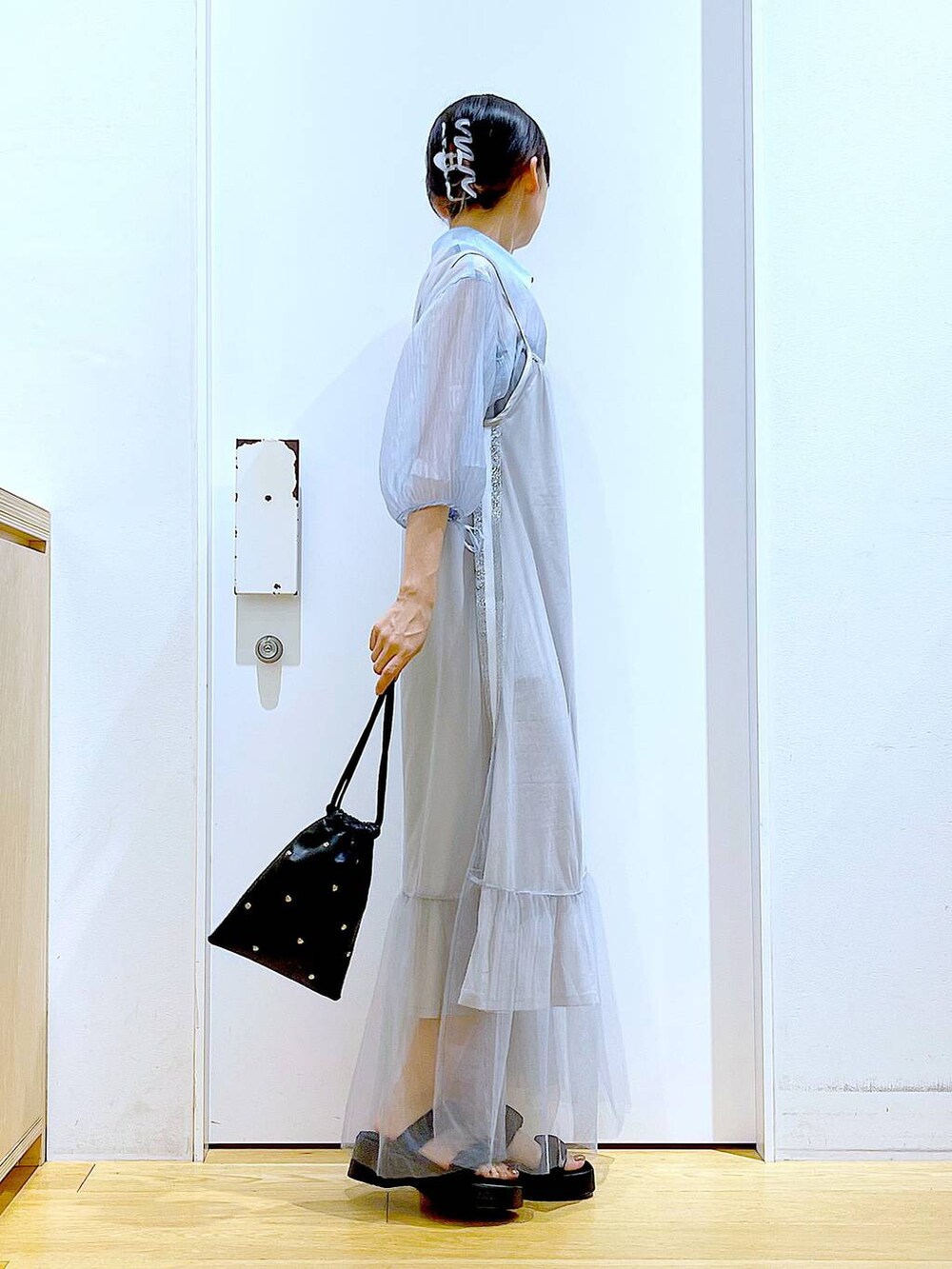 ブラック系のサンダル、ブラック系のショルダーバッグ、ブルー系のシャツ/ブラウスを着用したレディースの夏コーディネートの4枚目の写真