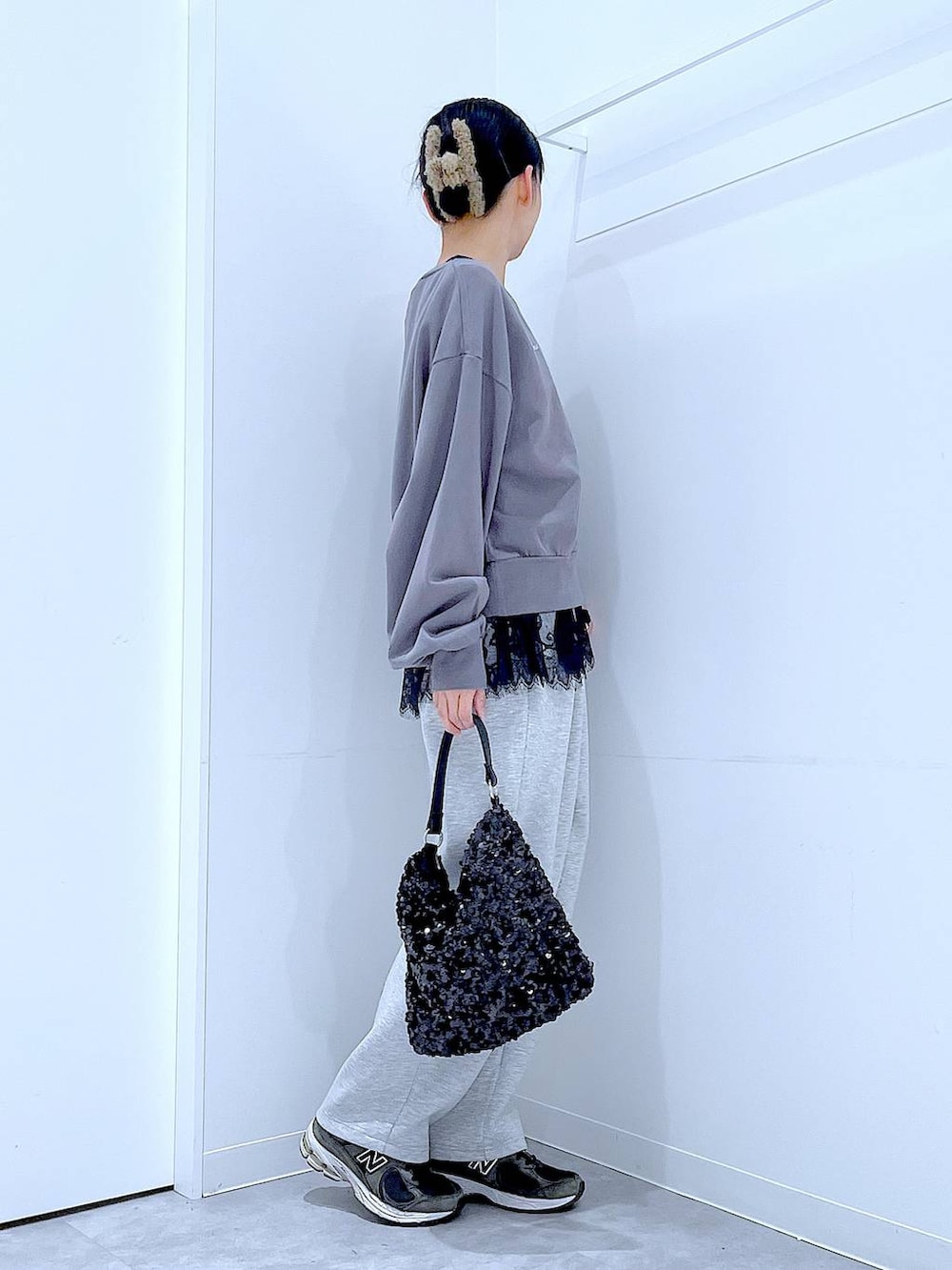 グレー系のスウェット、ブラック系のショルダーバッグ、ブラック系のタンクトップを着用したレディースの春コーディネートの4枚目の写真