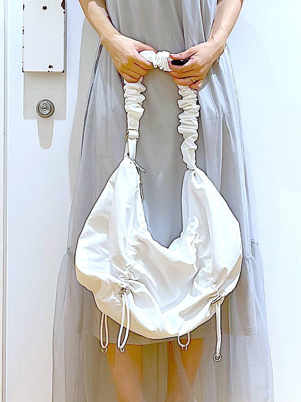 ホワイト系のサンダル、グレー系のTシャツ/カットソー、ホワイト系のショルダーバッグを着用したレディースの夏コーディネートの9枚目の写真