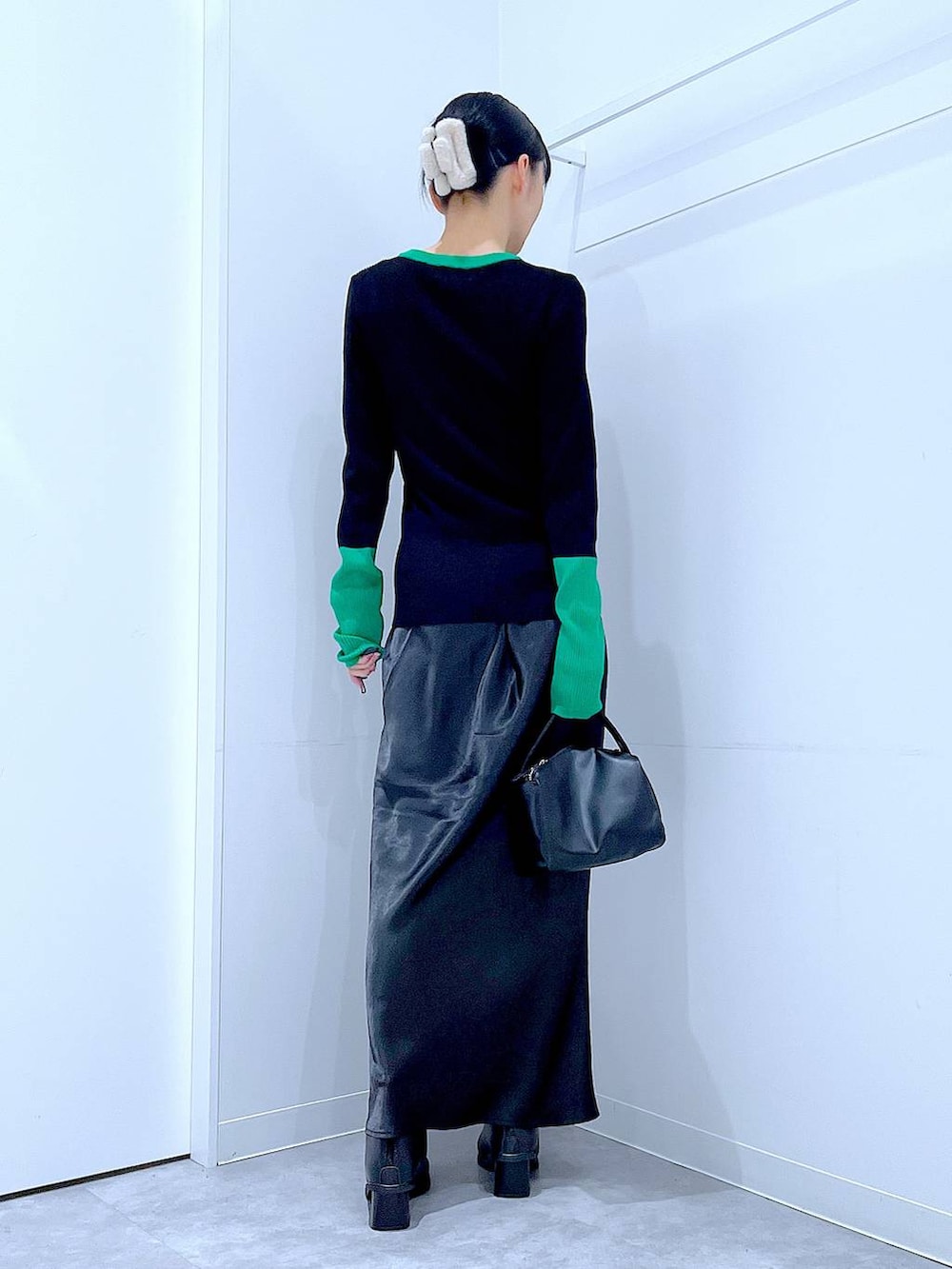 ブラック系のブーツ、ブラック系のショルダーバッグ、ブラック系のニット/セーターを着用したレディースの冬コーディネートの5枚目の写真