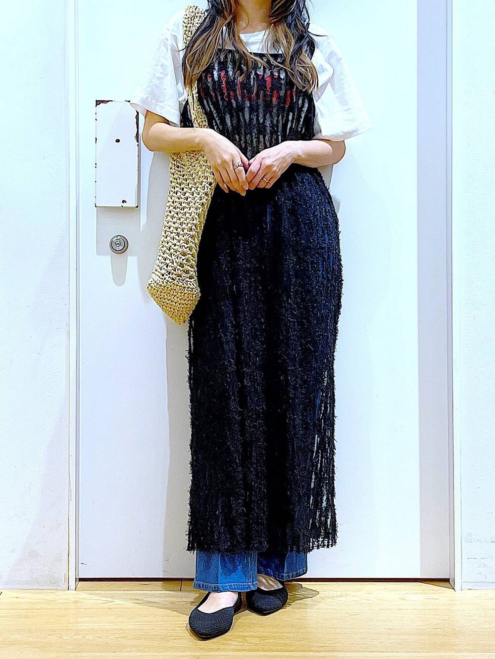 ブルー系のデニムパンツ、ブラック系のワンピース、ブラック系のパンプスを着用したレディースの春コーディネートの6枚目の写真