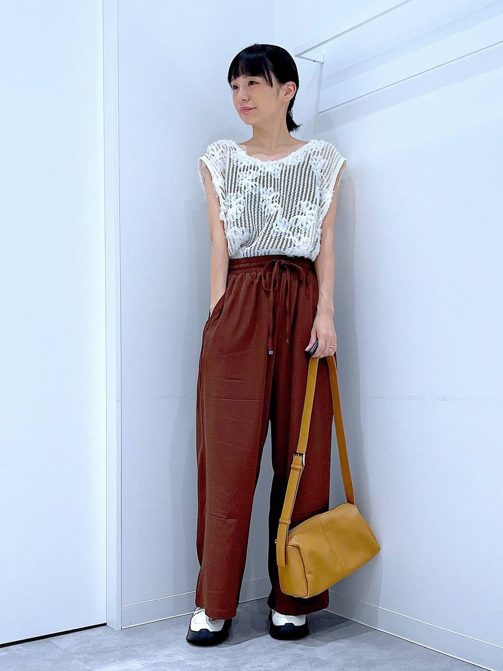 ベージュ系のショルダーバッグ、ホワイト系のローファー、ブラウン系のその他パンツを着用したレディースの秋コーディネートの2枚目の写真