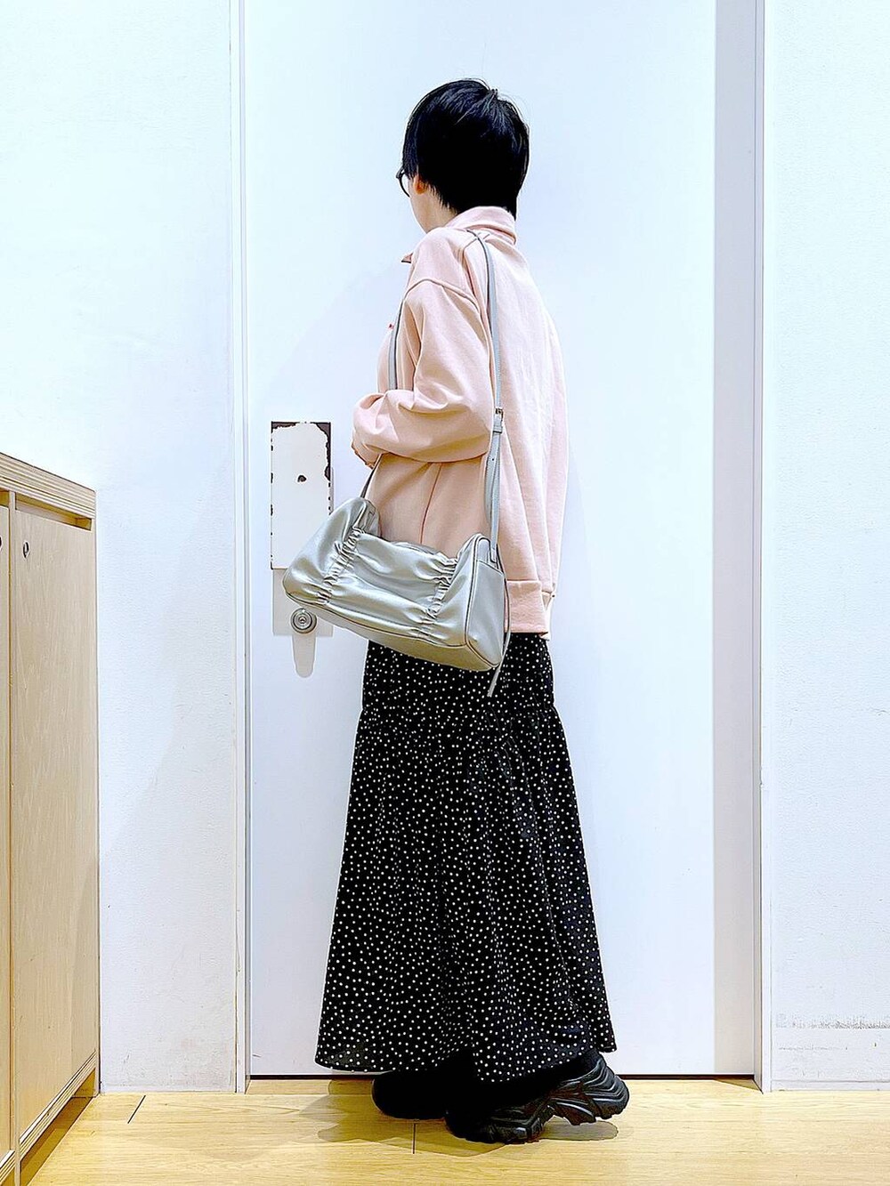 ブラック系のブーツ、シルバー系のショルダーバッグ、その他のスカートを着用したレディースの冬コーディネートの3枚目の写真