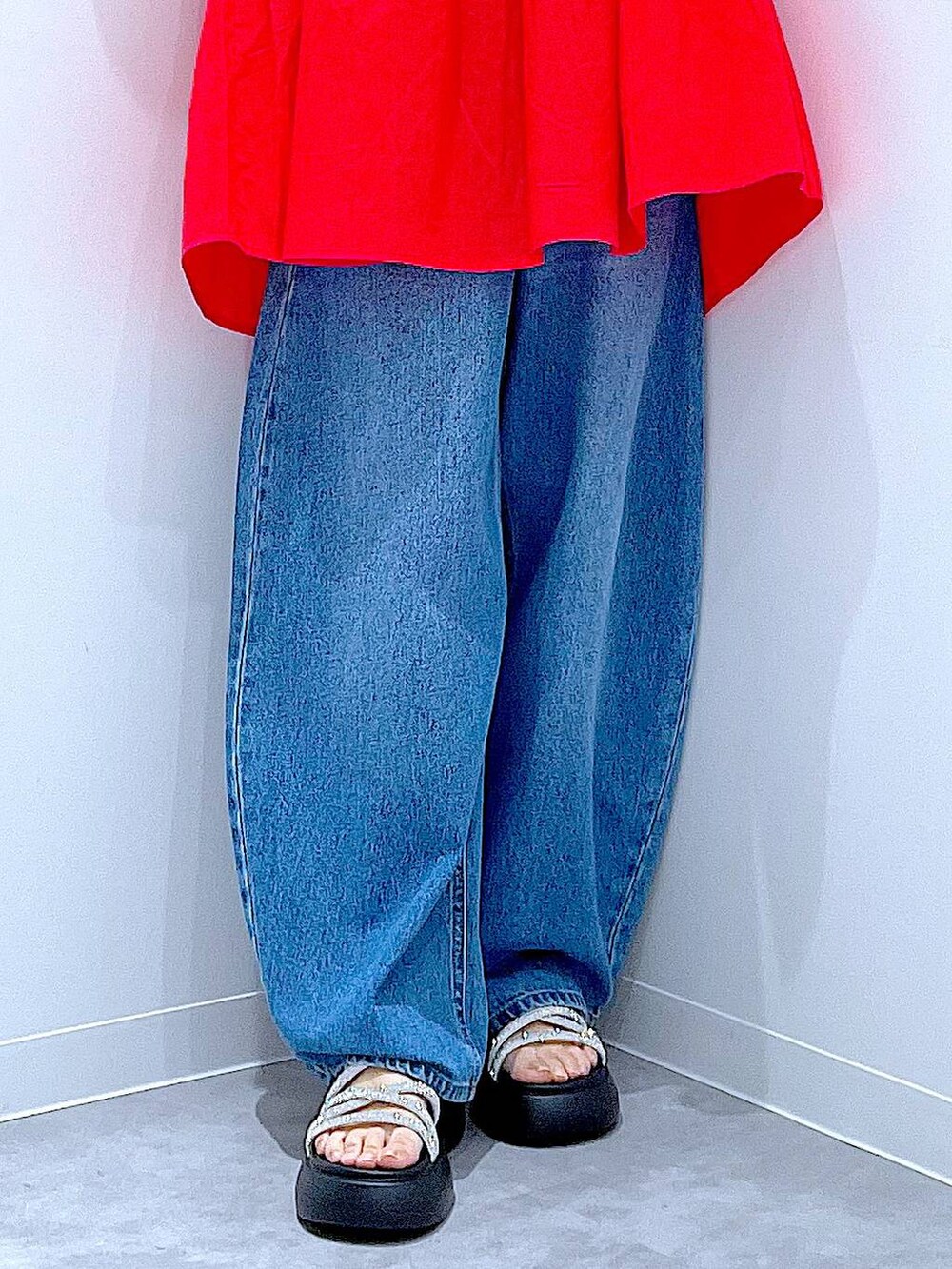 ブルー系のデニムパンツ、ブラック系のショルダーバッグ、シルバー系のサンダルを着用したレディースの夏コーディネートの8枚目の写真