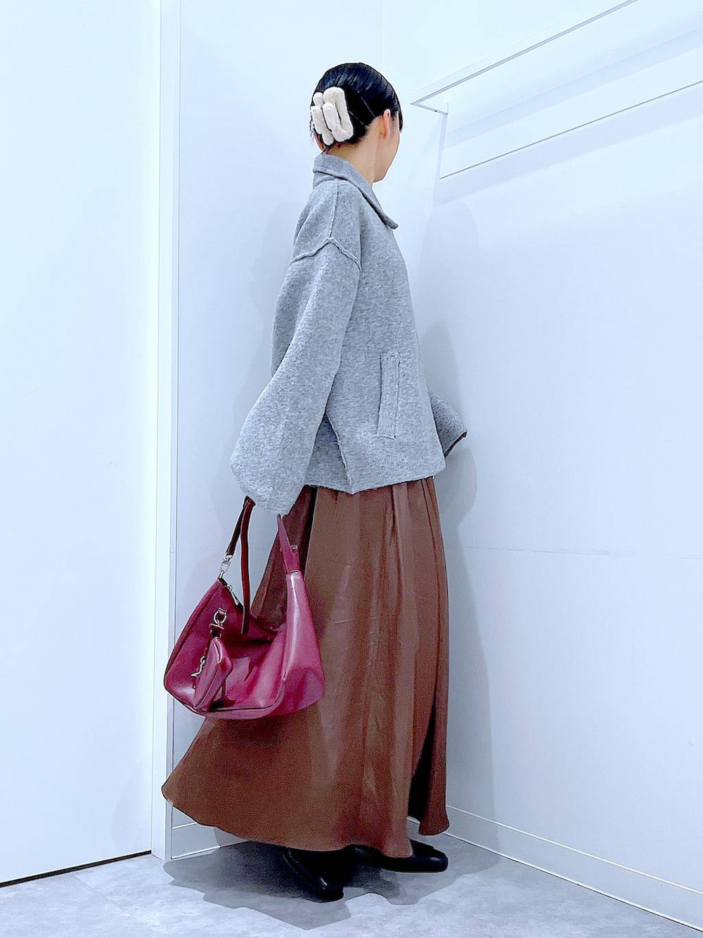 グレー系のブルゾン、ブラック系のブーツ、レッド系のショルダーバッグを着用したレディースの冬コーディネートの4枚目の写真