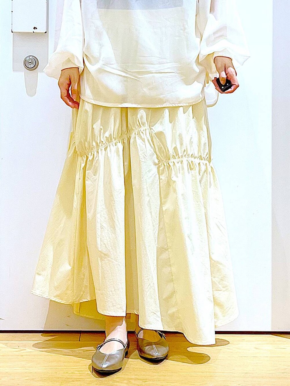 その他のパンプス、ブルー系のトートバッグ、ベージュ系のその他トップスを着用したレディースの春コーディネートの8枚目の写真