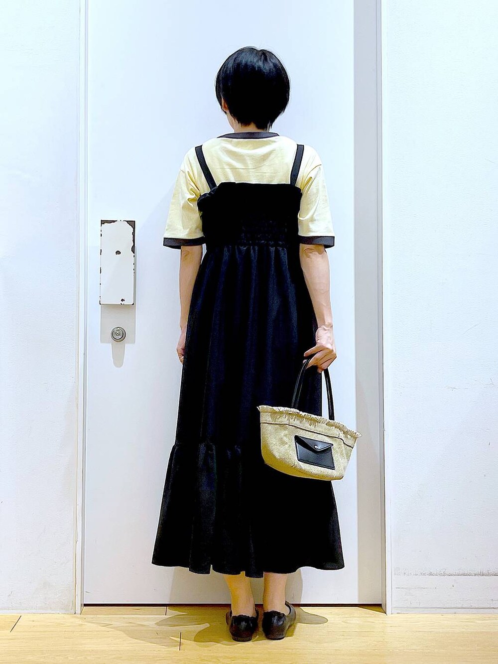 ブラック系のパンプス、ベージュ系のショルダーバッグ、ブラック系のワンピースを着用したレディースの夏コーディネートの5枚目の写真