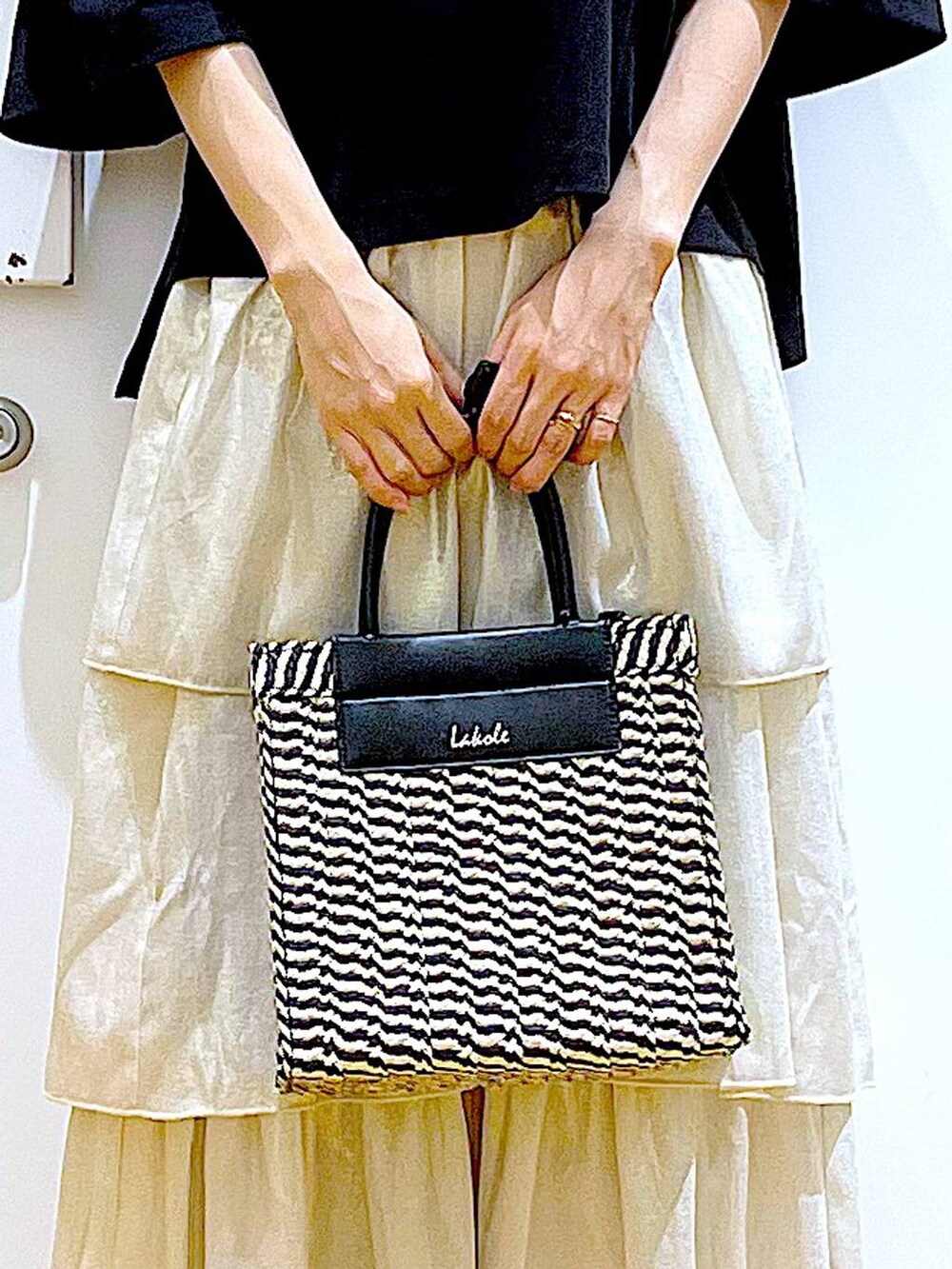 ブラック系のサンダル、ブラック系のショルダーバッグ、ゴールド系のスカートを着用したレディースの夏コーディネートの9枚目の写真