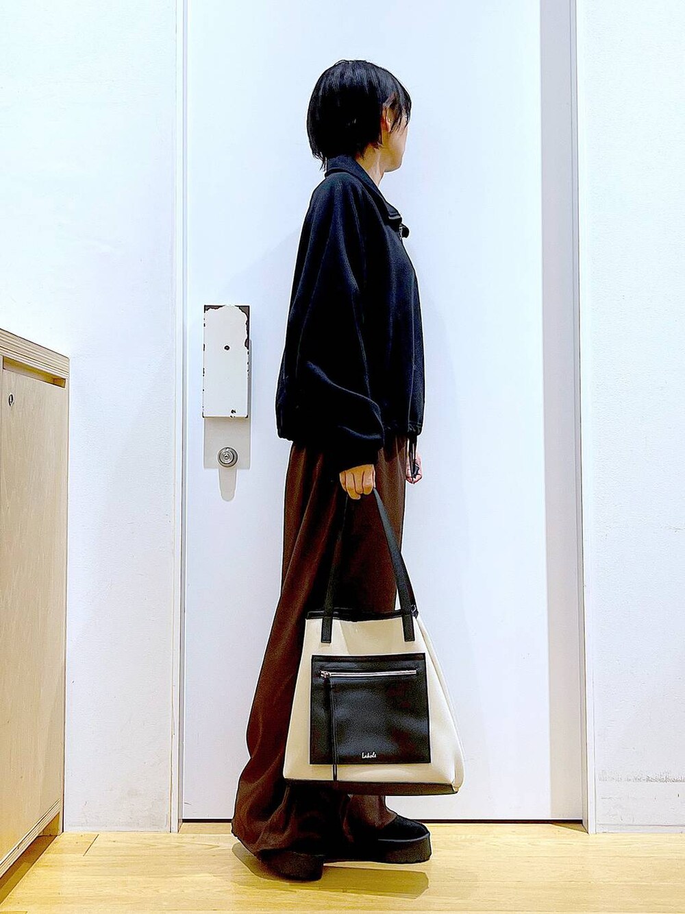 ブラック系のスリッポン、ブラウン系のその他パンツ、ホワイト系のトートバッグを着用したレディースの秋コーディネートの4枚目の写真