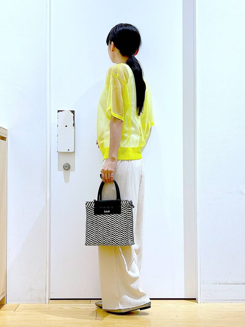 イエロー系のニット/セーター、ホワイト系のその他パンツ、ホワイト系のニット/セーターを着用したレディースの夏コーディネートの3枚目の写真