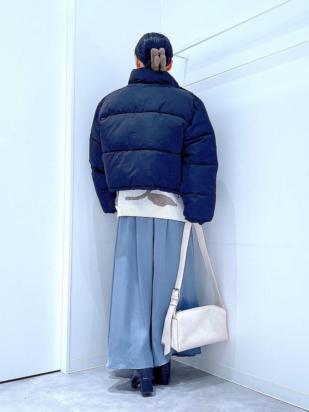 ブラック系のブルゾン、ブラック系のブーツ、ベージュ系のニット/セーターを着用したレディースの冬コーディネートの5枚目の写真