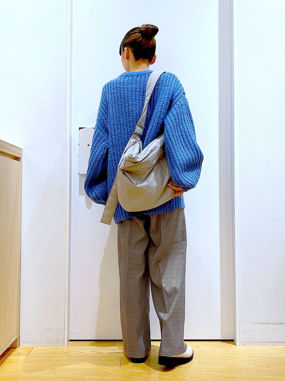 ベージュ系のブーツ、グレー系のショルダーバッグ、ベージュ系のスラックスを着用したレディースの冬コーディネートの5枚目の写真