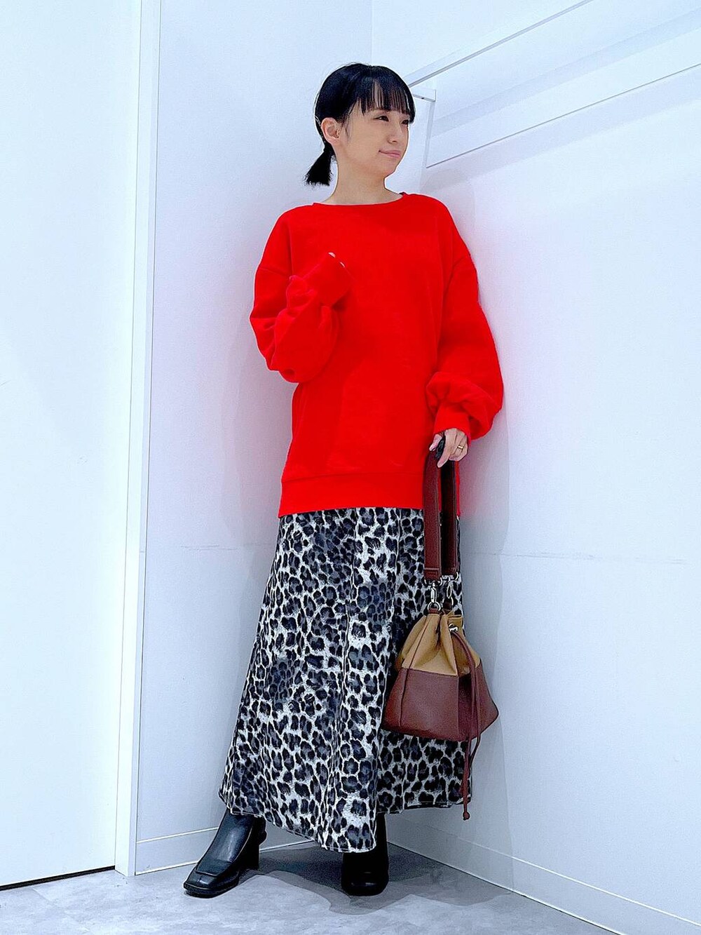 ベージュ系のショルダーバッグ、ブラック系のブーツ、グレー系のスカートを着用したレディースの秋コーディネートの2枚目の写真