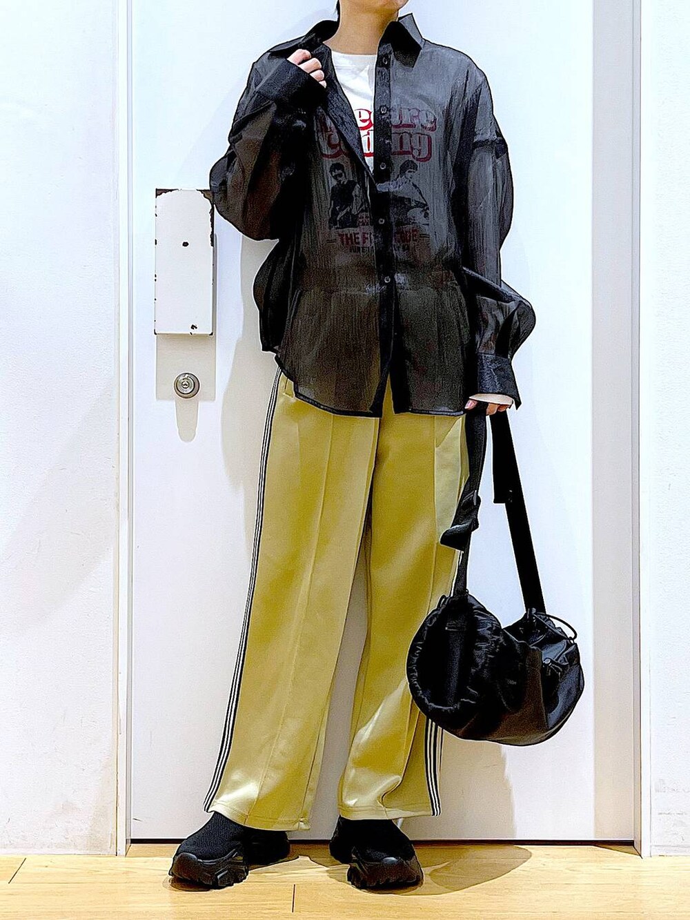 グリーン系のその他パンツ、ブラック系のスニーカー、ブラック系のショルダーバッグを着用したレディースの春コーディネートの6枚目の写真