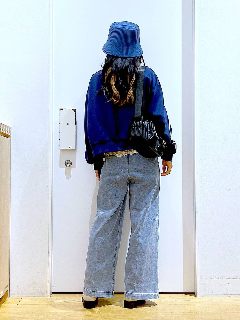 ブルー系のデニムパンツ、ベージュ系のブーツ、ブラック系のショルダーバッグを着用したレディースの冬コーディネートの5枚目の写真