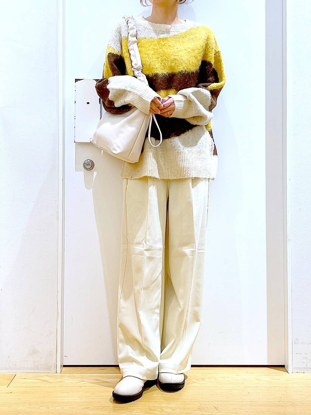 ホワイト系のショルダーバッグ、ベージュ系のブーツ、ベージュ系のその他パンツを着用したレディースの冬コーディネートの6枚目の写真