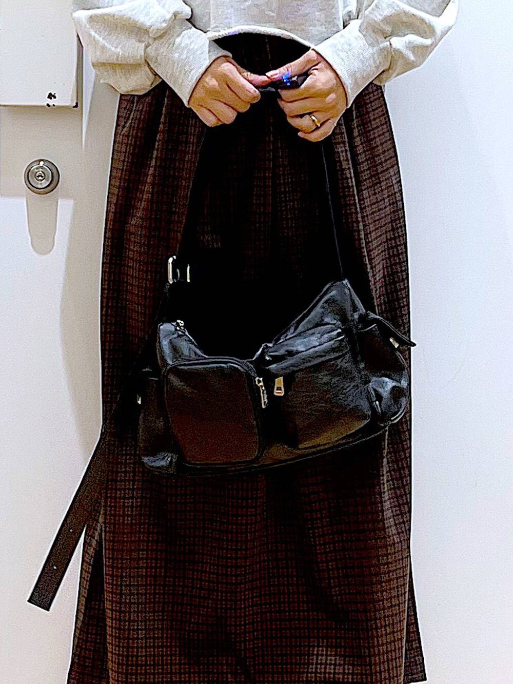 ブラック系のブーツ、ブラック系のショルダーバッグ、ブラウン系のワンピースを着用したレディースの冬コーディネートの9枚目の写真