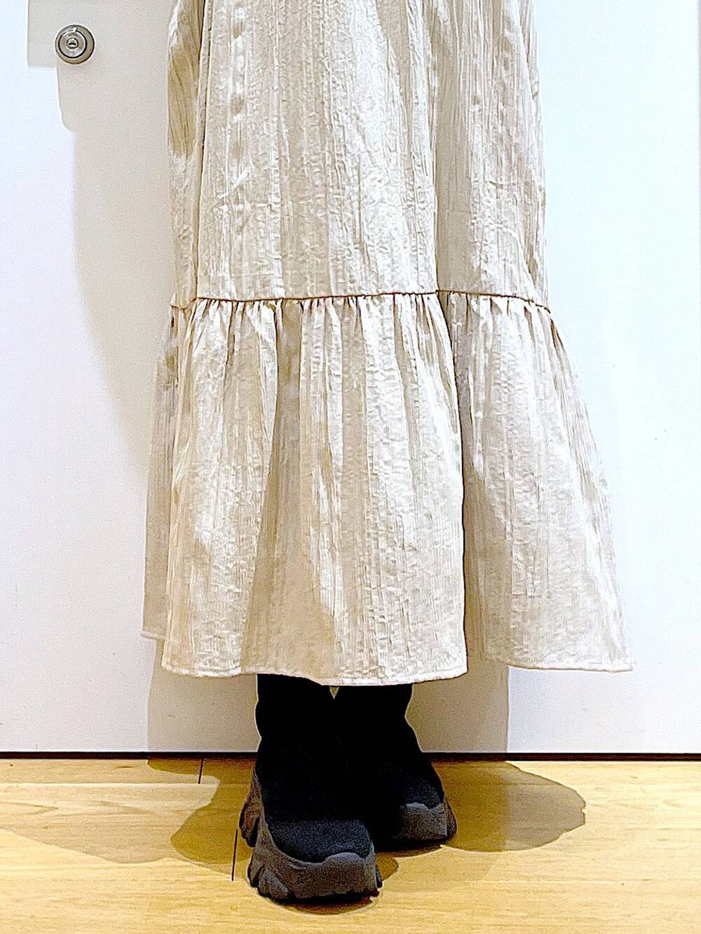 ブラック系のショルダーバッグ、ブラック系のブーツ、ベージュ系のワンピースを着用したレディースの冬コーディネートの8枚目の写真