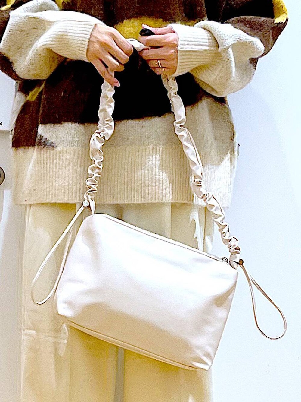 ホワイト系のショルダーバッグ、ベージュ系のブーツ、ベージュ系のその他パンツを着用したレディースの冬コーディネートの9枚目の写真