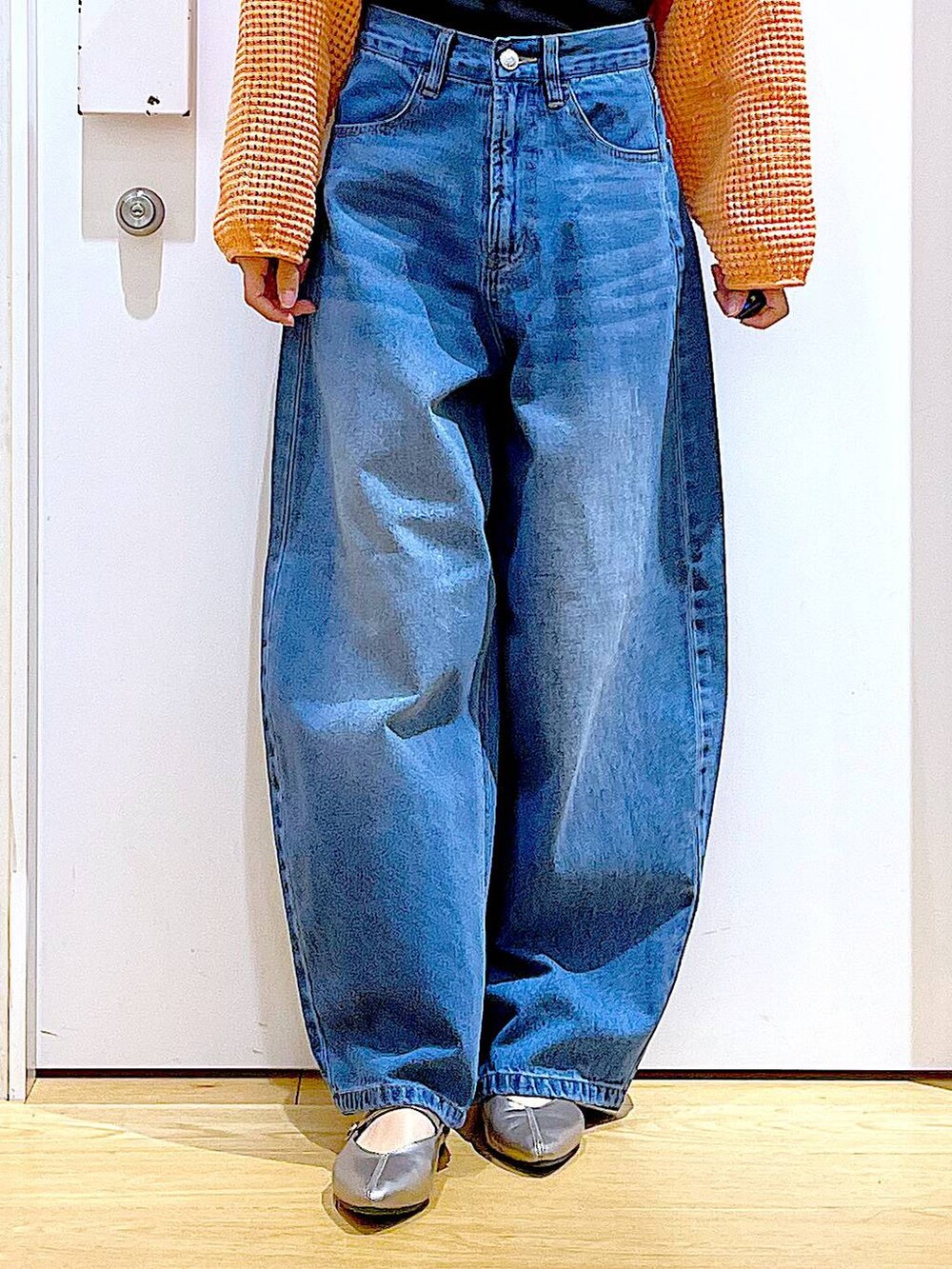 ブルー系のデニムパンツ、オレンジ系のカーディガン/ボレロ、その他のパンプスを着用したレディースの春コーディネートの8枚目の写真