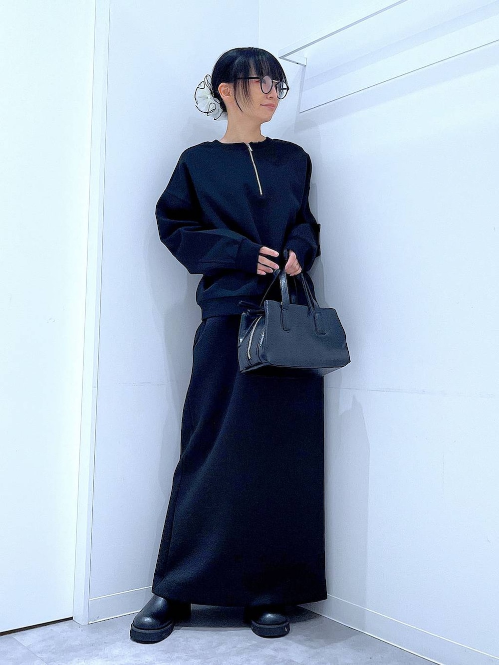 ブラック系のボストンバッグ、ブラック系のスウェット、ブラック系のスカートを着用したレディースの春コーディネートの2枚目の写真